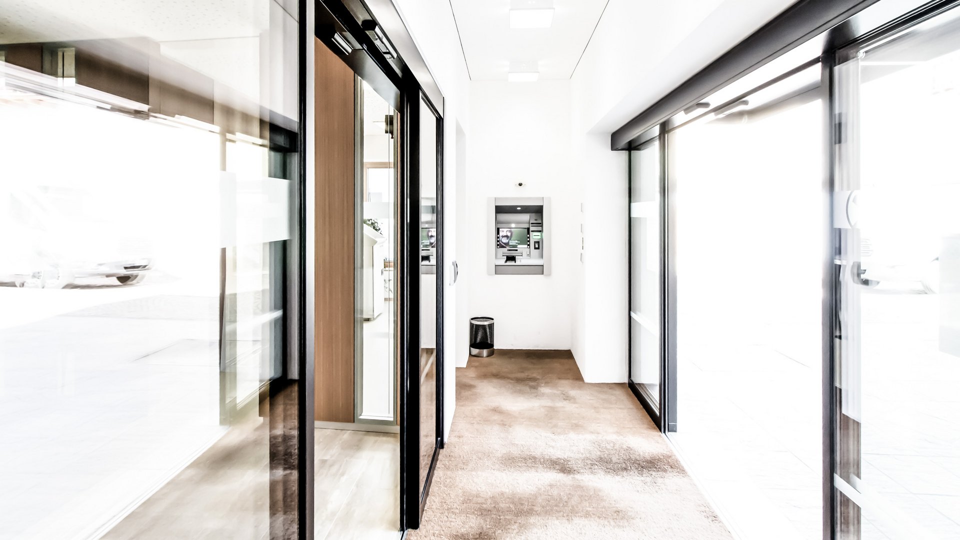 Eingangsbereich der Raiffeisenkasse in Schulderns, Italien mit einer automatischen Schiebetür