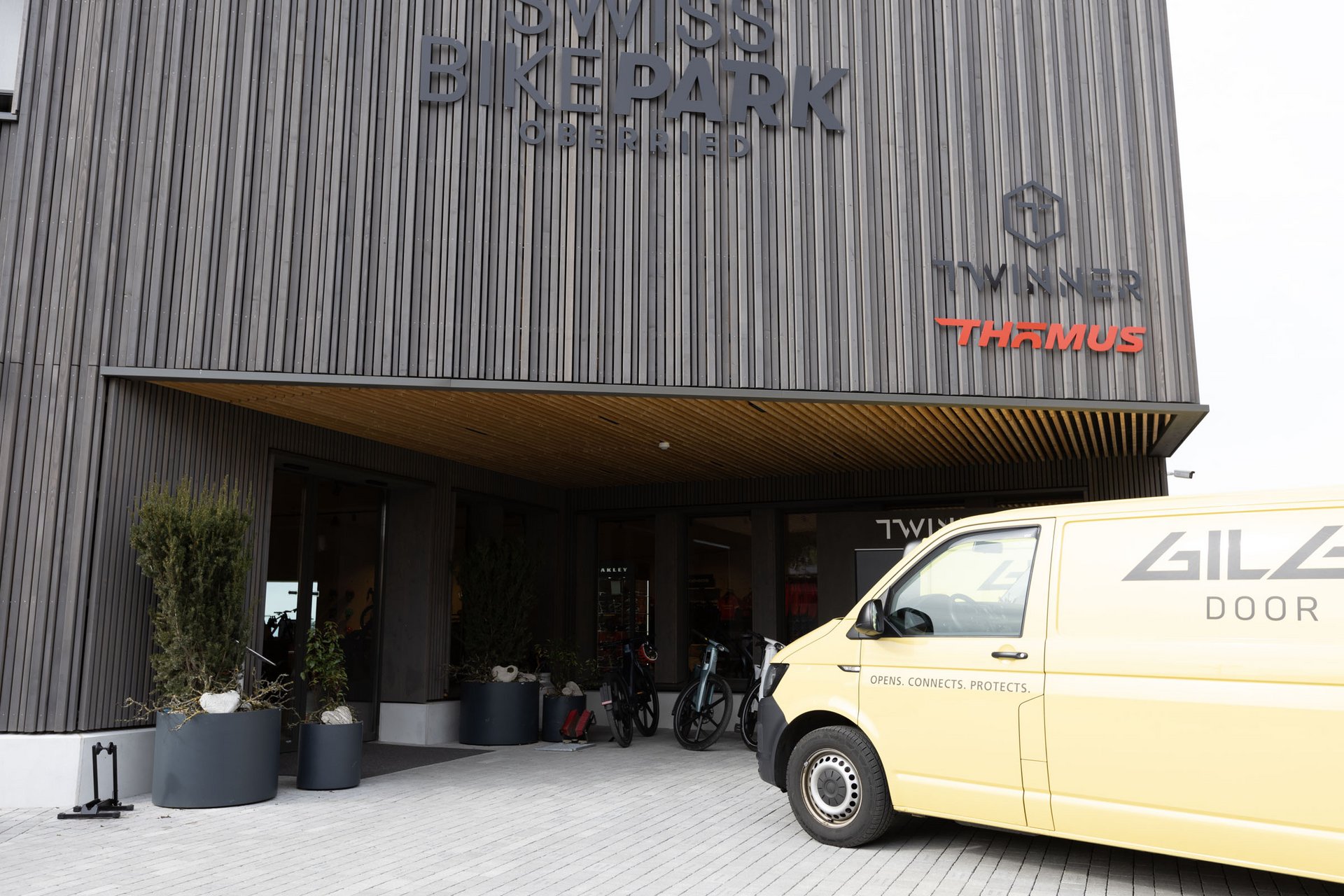 Eingang des Swiss Bike Parks in Oberried mit einer automatischen Schiebetür und einem Kundendienstfahrzeug von Gilgen Door Systems