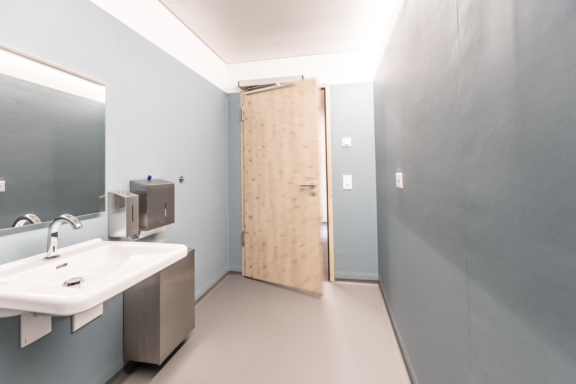 Toilette des Swiss Bike Parks in Oberried mit einer automatischen Drehflügeltür